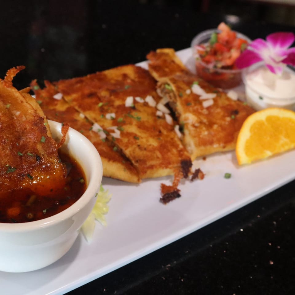 Quesadilla platter with dipping sauce, pico de gallo, crema, and guacamole.